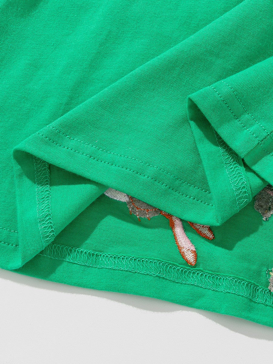 BabyEase green cotton dress fabric detail showing embroidered mouse and dandelion appliqué stitching
